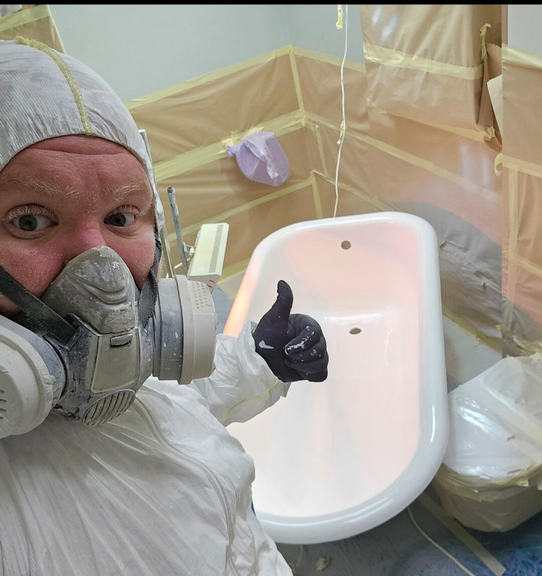 photo of glossy baths owner photo of glossy baths re-enamelling owner Seamus with a thumbs up, in ppe, in a room full of masking up and a completed bath in Worcester